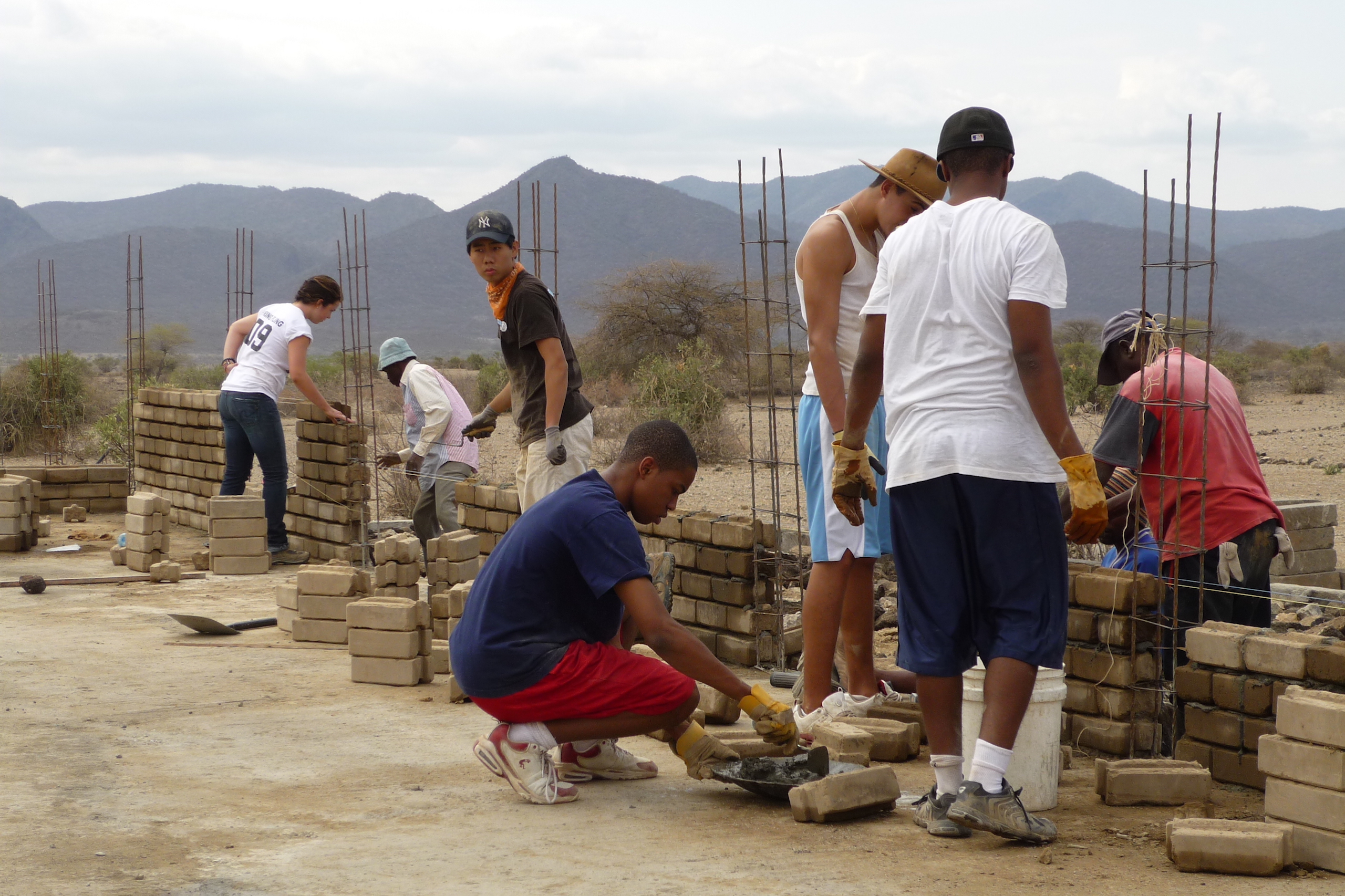 Student led work crew building compressed earth block walls in Oloika, Kenya